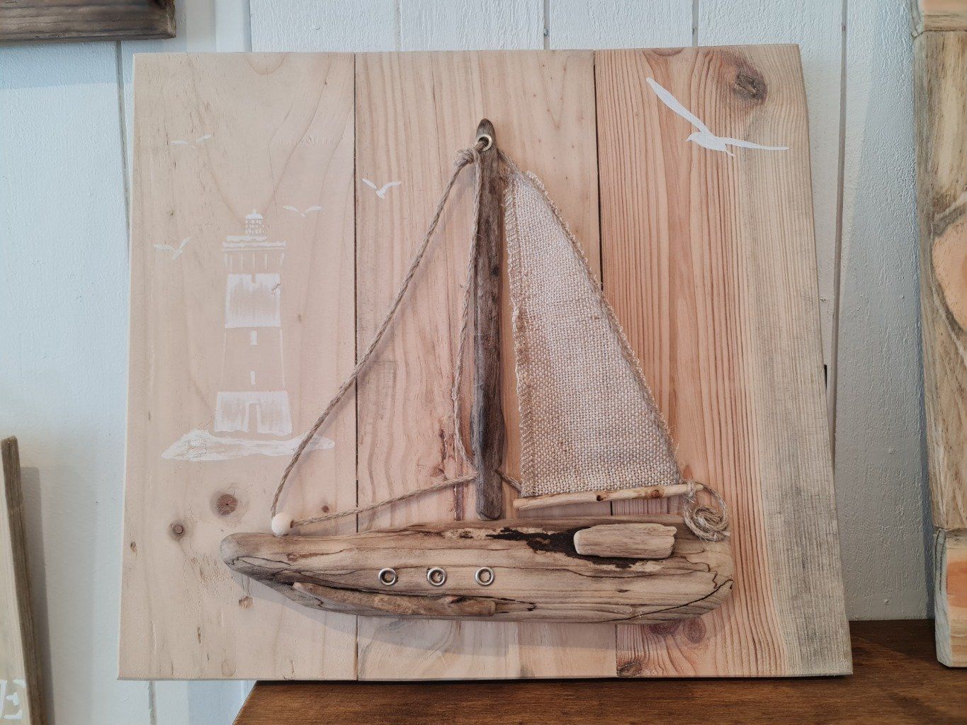 assemblage de morceaux de palette recoupés . voilier en bois flottés et voile tissu .