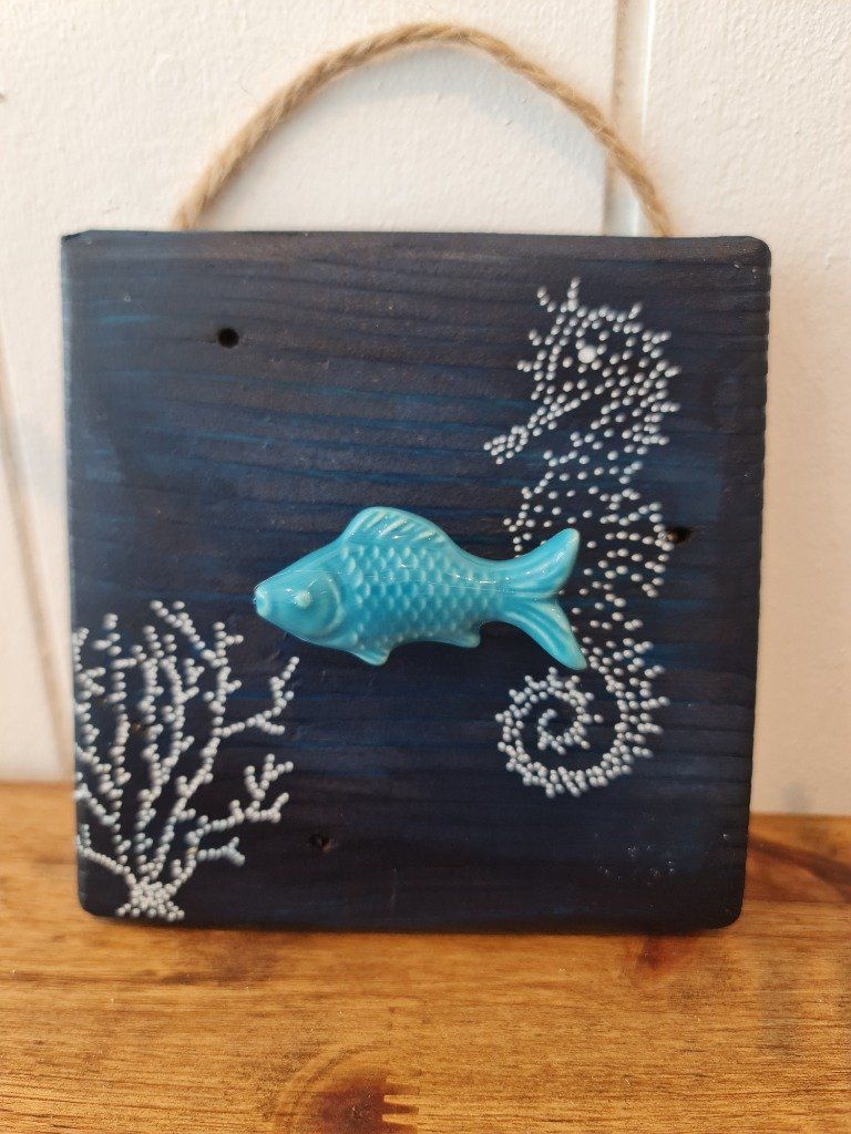 Patère poisson céramique turquoise sur palette recoupée en carré.