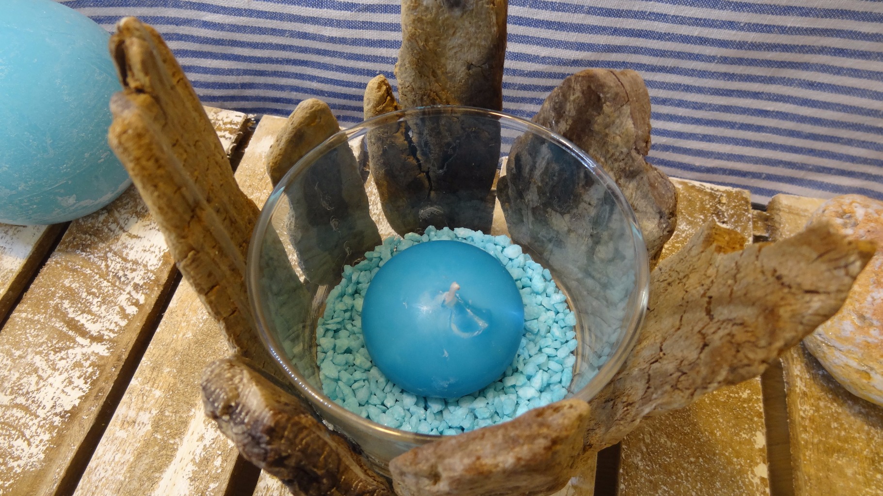 Photophore composé d'un verre recyclé , de bois ramassés sur les dunes.
Du sable et une bougie bleu .